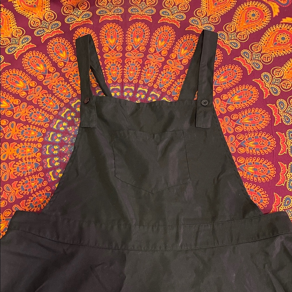 Black pinafore with adjustable straps and front bib pocket